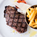 plate of steak and chips with a tomato