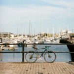 bike resting by rails near the sea