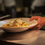 hand passing food in a bowl over pass