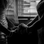 a couple holding hands in front of a window