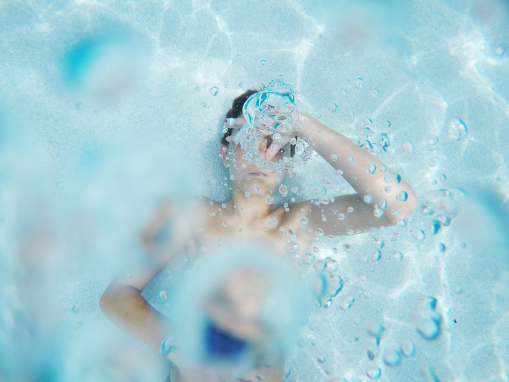 boy with goggles swimming in pool