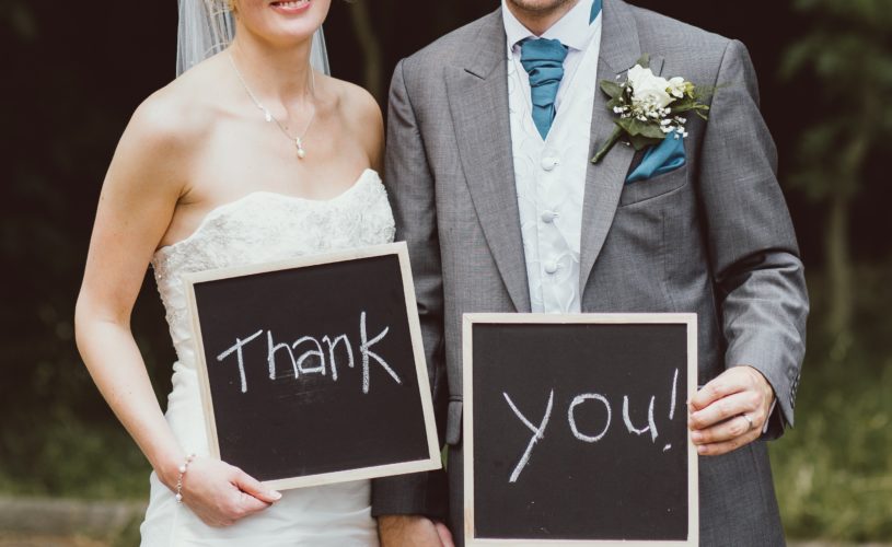 couple with chalk boards saying thank you after wedding