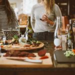 kitchen with people talking around island of food