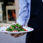 Waiter with food green leaf salad