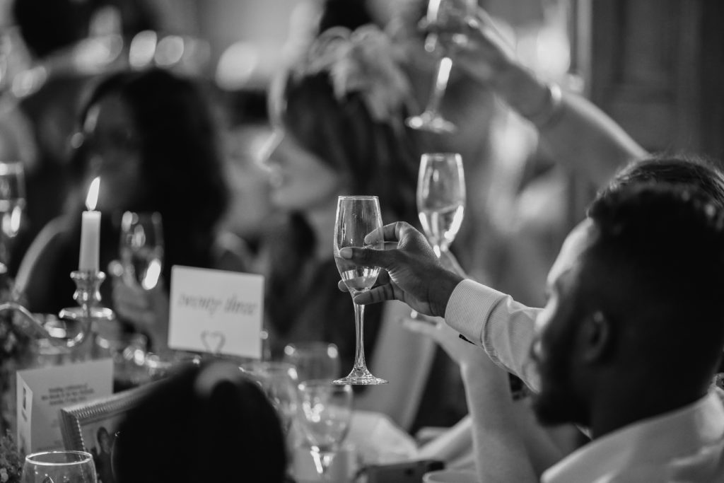 black and white phot of people toasting at a wedding