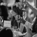black and white phot of people toasting at a wedding