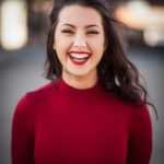 lady in red top with brown hair and red lips